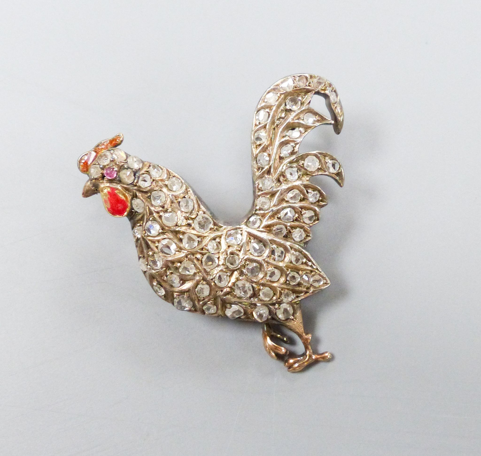 A Victorian yellow and white metal, enamel and rose cut diamond set cockerel pendant, now with later brooch attachment, enamel a.f, 37mm, gross weight 8.8 grams.